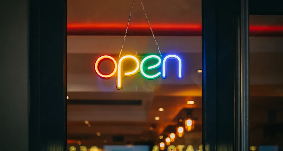 Podświetlony szyld OPEN w witrynie lokalnego biznesu